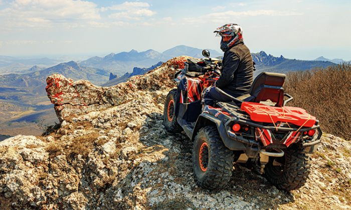 PERSON RIDING ATV UP IN THE MOUNTAINS